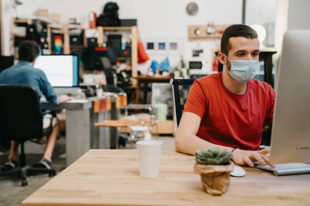 istock Colleagues are working together in their office, wearing protective face masks 1243664570