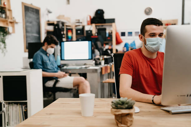istock Colleagues are working together in their office, wearing protective face masks 1243664576