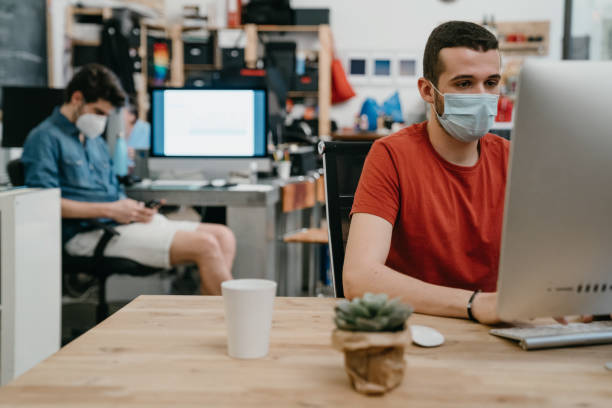 istock Colleagues are working together in their office, wearing protective face masks 1243664579