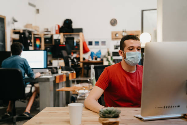 istock Colleagues are working together in their office, wearing protective face masks 1243664594