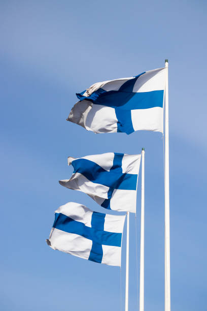 istock Three finnish national flags on the wind against the blue sky 1243667950