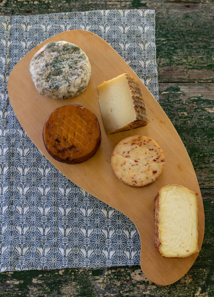 istock Top view of assorted cheeses on a rustic wooden board. Blue cheese, cured cheese, Manchego cheese, smoked cheese 1243672198