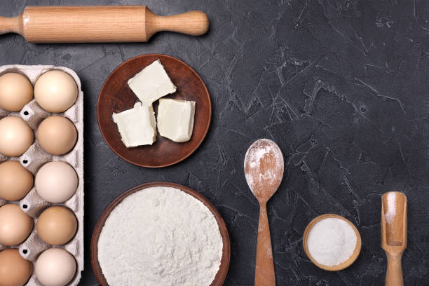 istock Eggs, flour and rolling pin on a dark background. Free space for text. 1243692415