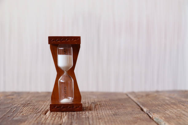 istock Little hourglass on wooden table 1243706299
