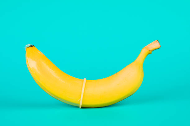 istock Condom and banana on a blue background close-up 1243718611