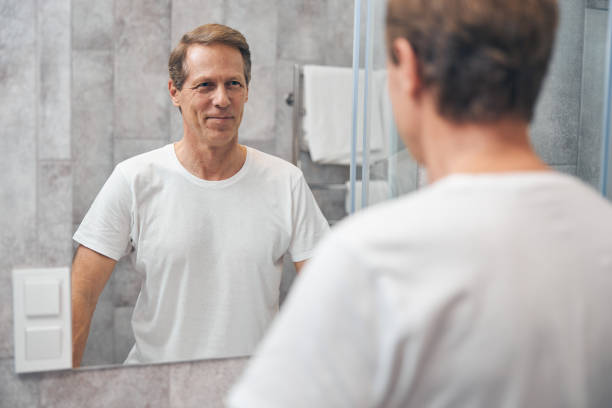istock Contented middle-aged male looking at his appearance 1243729003