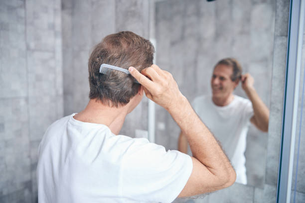 istock Man with a comb looking at the mirror 1243729026