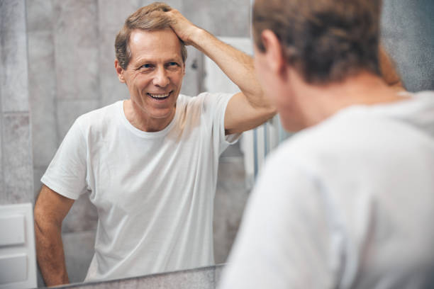 istock Male looking at himself in the mirror 1243729045