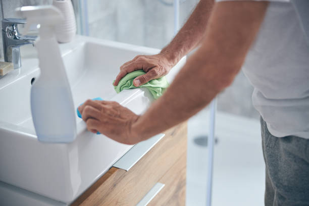 istock Man with a cloth standing at the sink 1243729587
