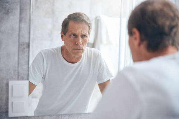 istock Sad person examining himself in the mirror 1243730174