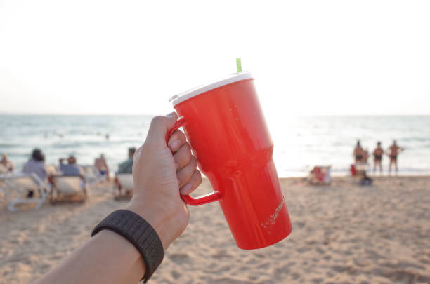 istock Red cup in sand at sunset. Summer beach party concept with copy space. 1243741972