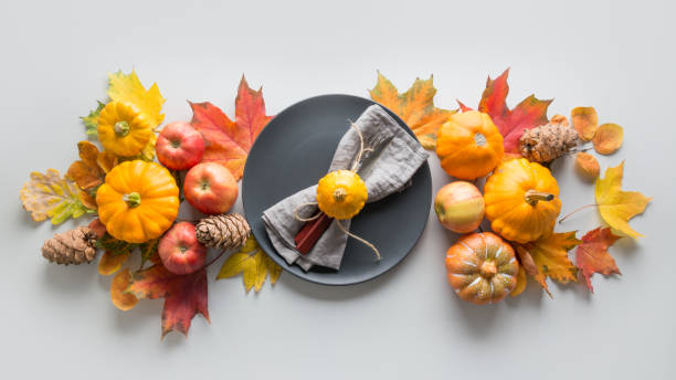 Fall table setting for Thanksgiving Day with pumpkins, leaves, apples on grey. View from above. Banner.