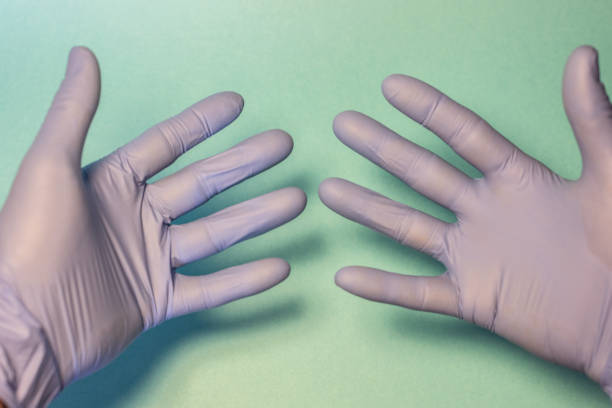 istock hands with sanitary gloves over green field 1243747277
