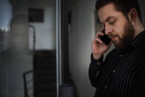 istock Young businessman stands by the window and uses his coffee break 1243762700