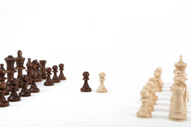 istock black and white pawn opposite each other on a white background. 1243764884