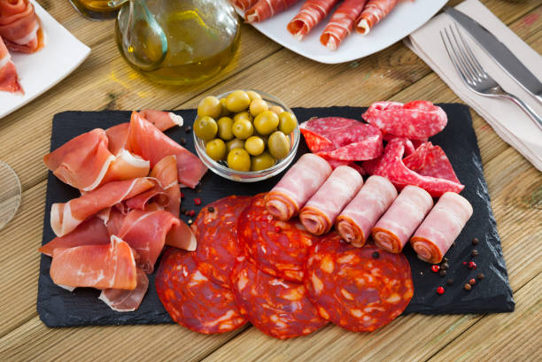 rebanadas de gammon, chorizo, salami, tocino en pizarra - serrano chilli pepper meat ham spain fotografías e imágenes de stock