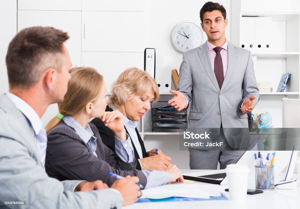 Managers Explaining Manager Explaining To Workgroup Plans Stock Photo - Download Image Now ...