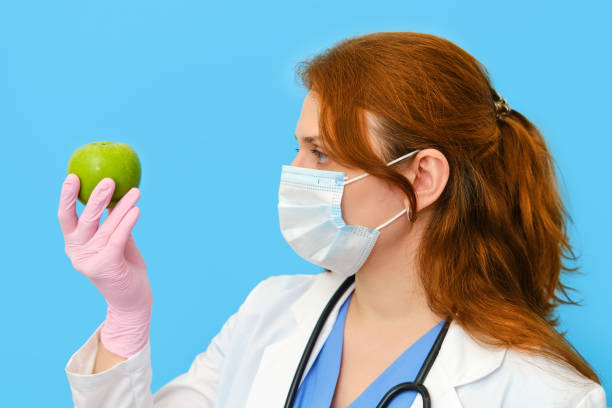 istock Doctor hand with an apple on a blue background 1243787376