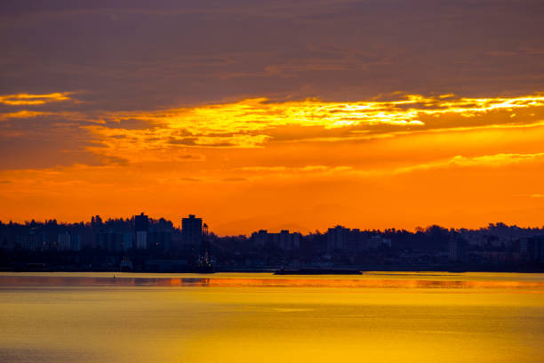 A vibrant sunset view over the Vancouver ferry port with calm waters and colorful sky.