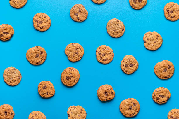 istock Chocolate chip cookies background. Cookies pattern on blue color 1243797733