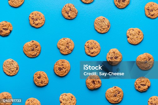 istock Chocolate chip cookies background. Cookies pattern on blue color 1243797733