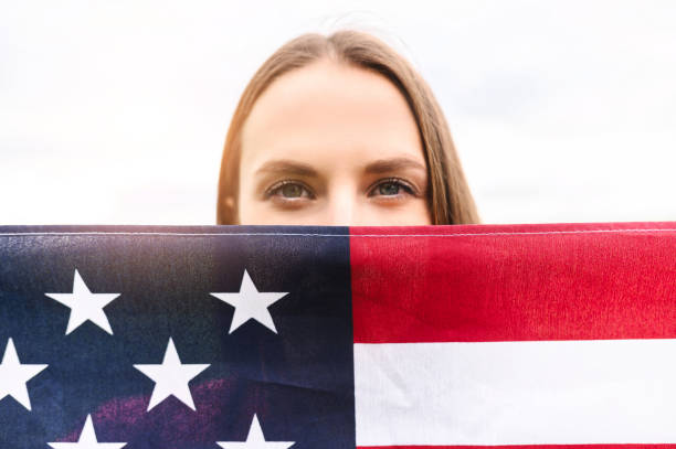 istock Woman covers half face with US flag 1243801036