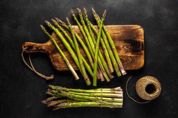 istock View of fresh asparagus on a black table. Food background. 1243808081
