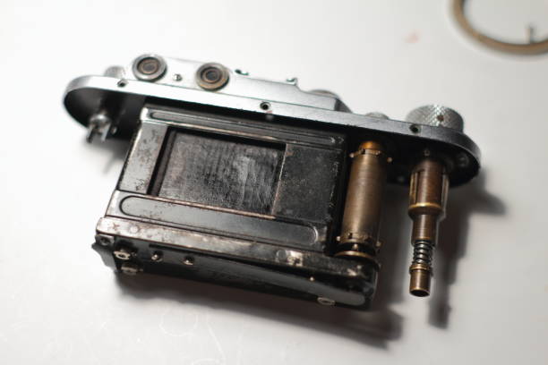 istock Disassembled vintage camera on a white table. Repair an old analog film camera. Selective focus. 1243810291
