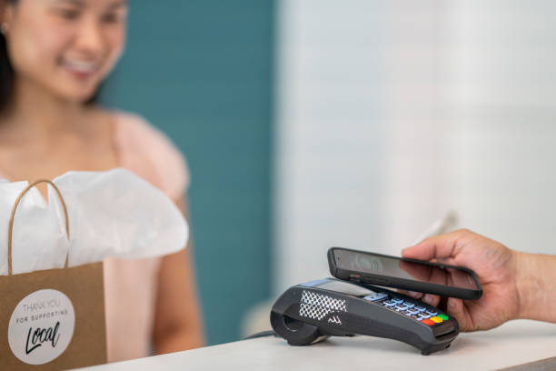 istock Customer using their smart phone to pay in a small boutique shop 1243821022