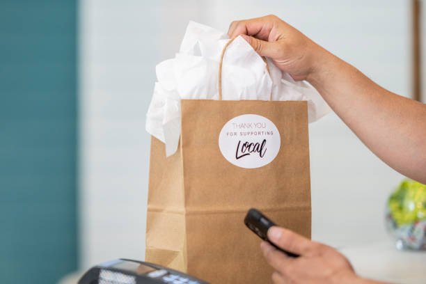 Customer using their smart phone to pay in a small boutique shop
