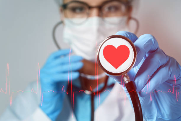 young female doctor cardiologist with a stethoscope - nurse illness doctor heart disease imagens e fotografias de stock