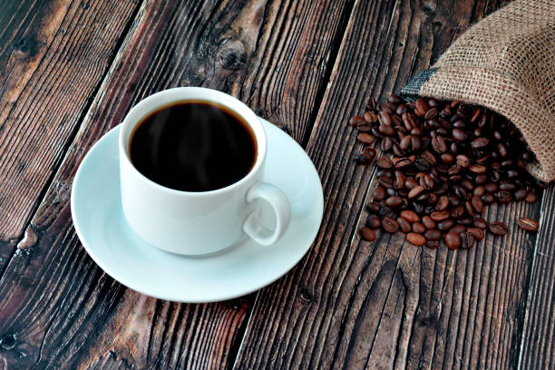 istock white cup of coffee on a wooden table with scattered grains 1243842250