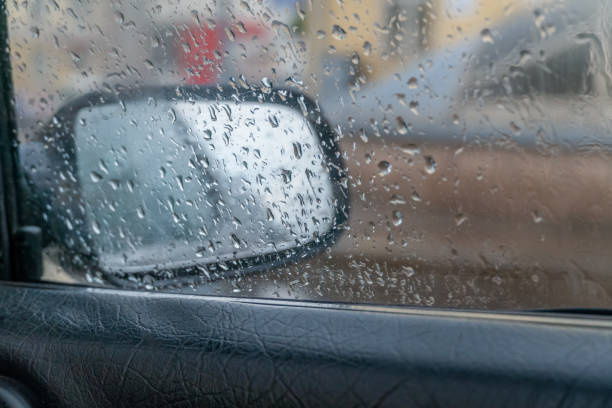 istock Blurred, focus on raindrops Rain drops on a car window with the mirror in the background. Mirror on the right side of the car 1243851873