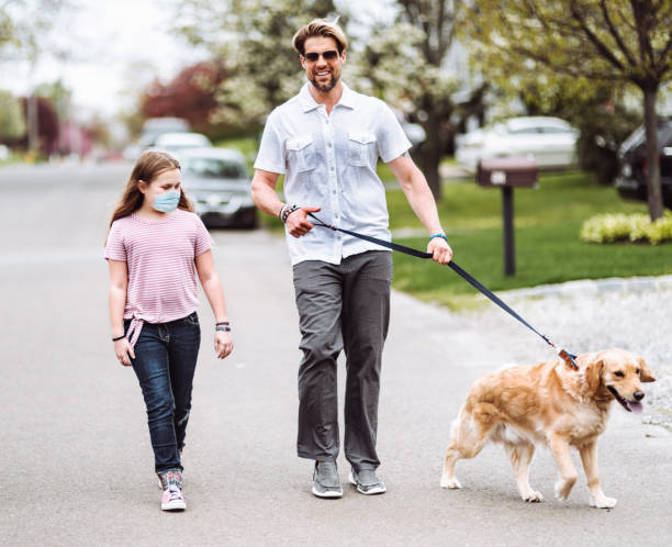 счастье семьи ходить с собакой на улице во время covid19 - community outreach child social worker waist up стоковые фото и изображения
