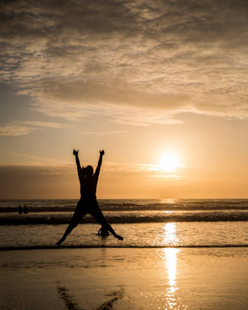 girl jumping on the beach in sunset