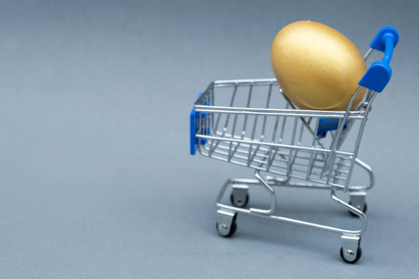 istock Golden egg with shopping cart isolated on gray background 1243868559