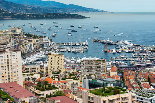 Nice, France - April 23, 2023: Many yachts of various sizes moored close together in Port Lympia. Buildings in the city are visible a little further out.