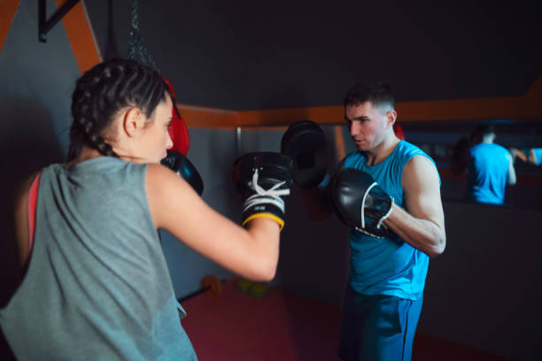 istock Young female boxer and her coach training with focus mitts 1243921326
