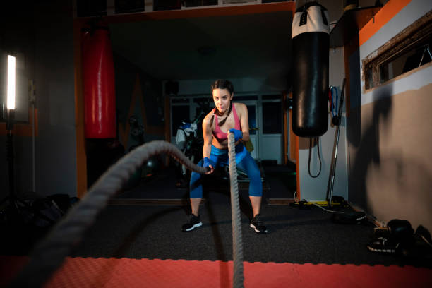 istock Young female athlete doing exercise with battle ropes 1243921333