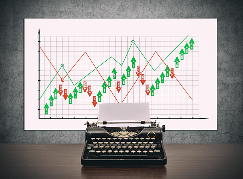 Vintage typewriter on on desk and banner with stock chart and statistic. Finance and trade concept.
