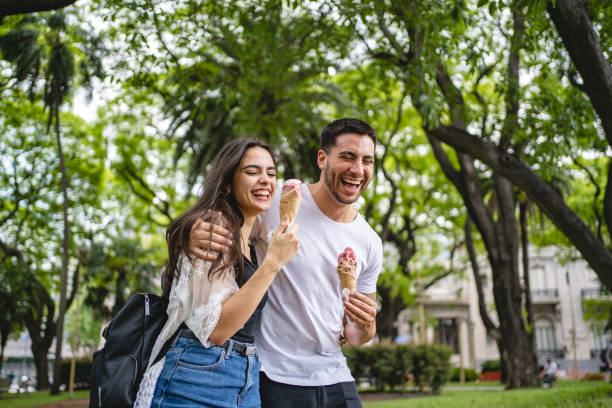 istock Young couple eating ice cream together while bonding in a public park 1243951316