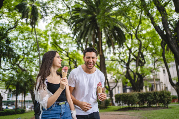 istock Joyful couple eating ice cream while bonding in a public park 1243951321