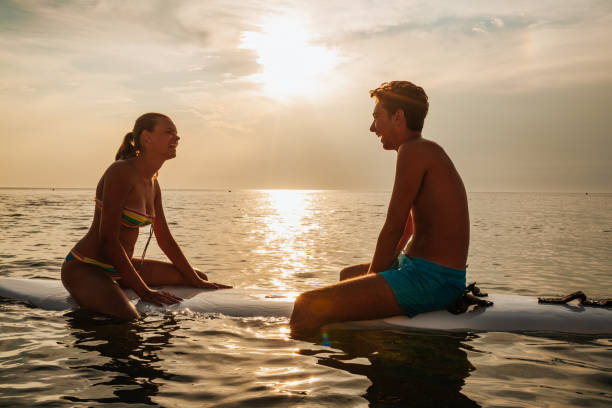 istock Young couple sitting on surfboard in sea 1243960778