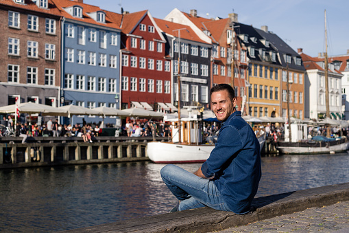 Man sitting on the edge of a dock in Copenhagen