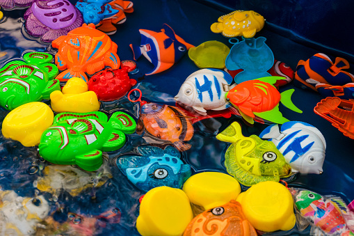 Childrens plastic colorful fish toys in the pool for playing in the fishing