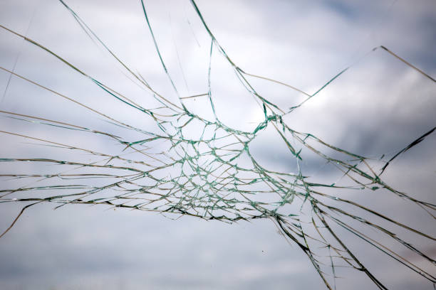 istock Broken Glass with Blue Sky and Clouds in Background. 1243998424