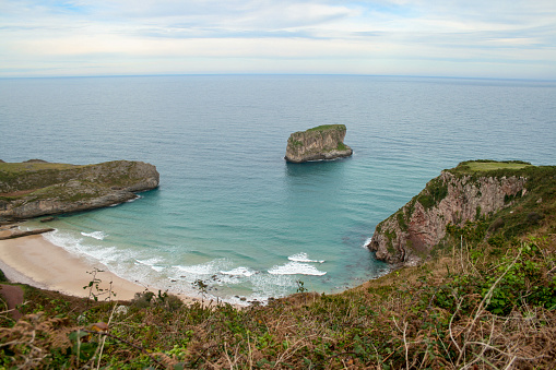 View of the coast, the Cantabrian Sea and the `La Soledad` beach from `El Tunel` in Laredo on a cloudy day