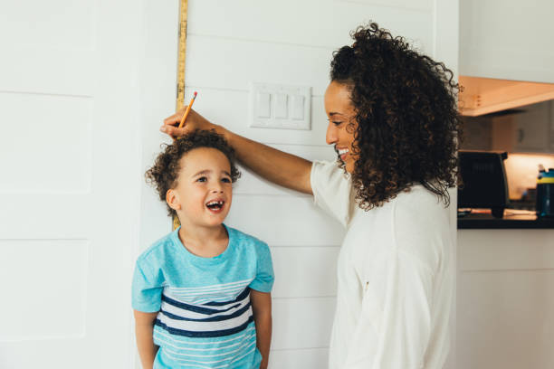 istock Mother Measuring Height of Son 1244032457