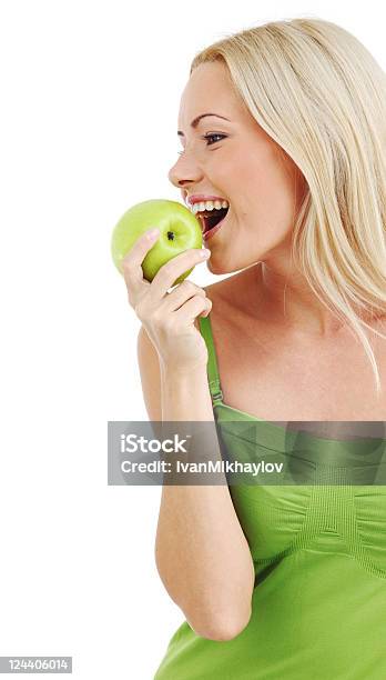 A Beautiful Blonde Woman Eats A Green Apple Stock Photo - Download Image Now - Adult, Adults Only, Apple - Fruit