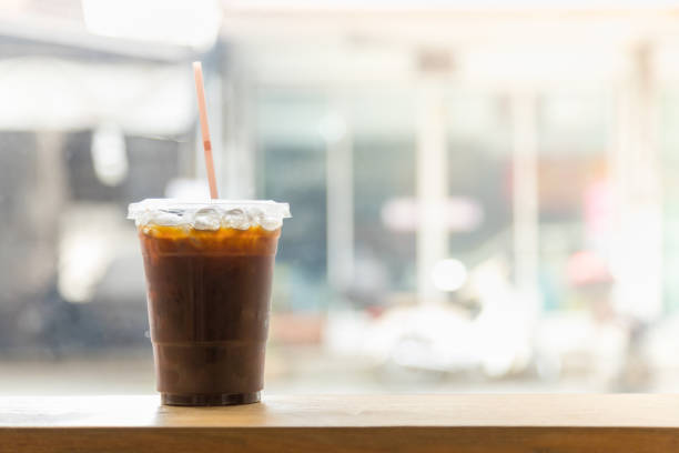 nahaufnahme von nehmen kunststoff tasse eis schwarzen kaffee (americano) im restaurant auf holztisch mit kopie sapce. - copy sapce stock-fotos und bilder